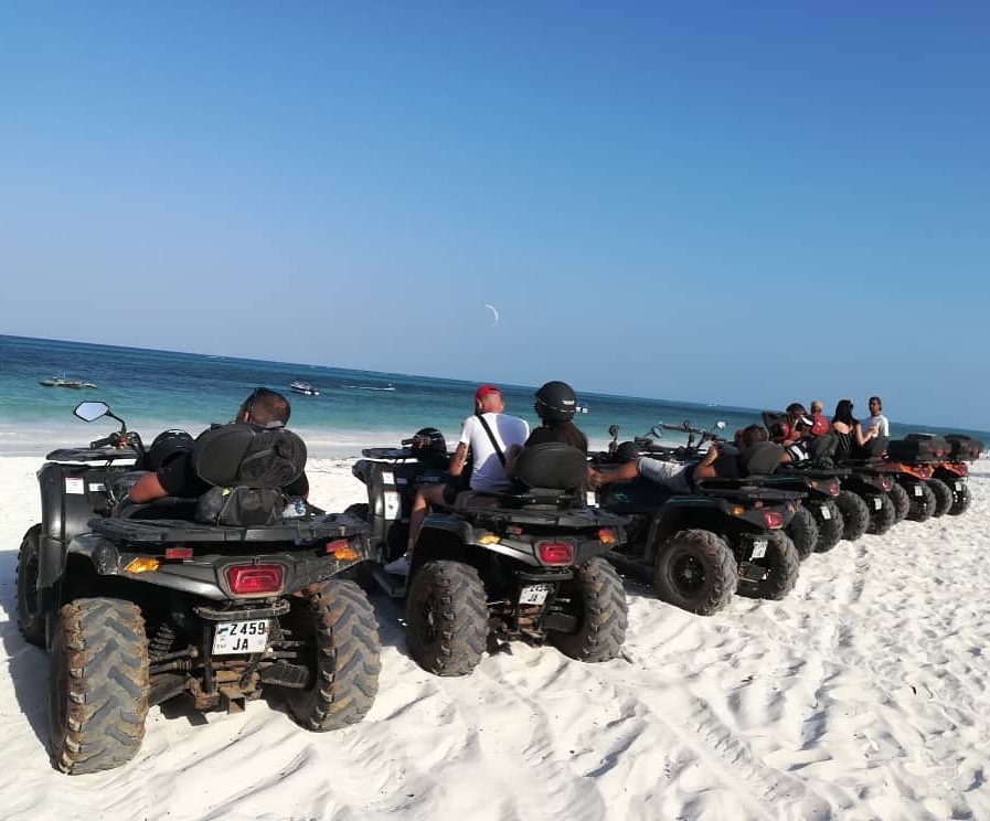 A group of quad bikers following a guide through a jungle path