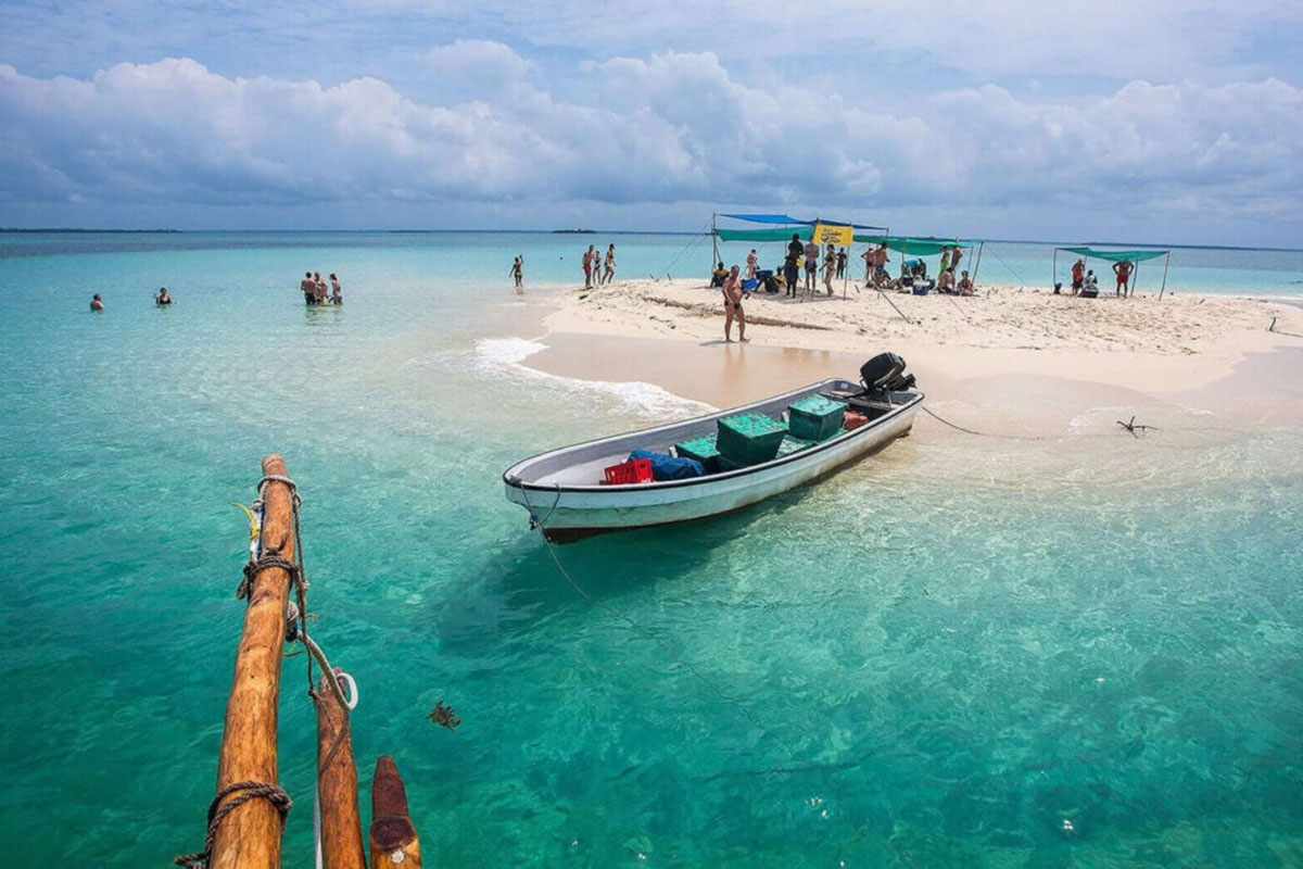 Tourists relaxing on a white sandbank in the middle of the ocean